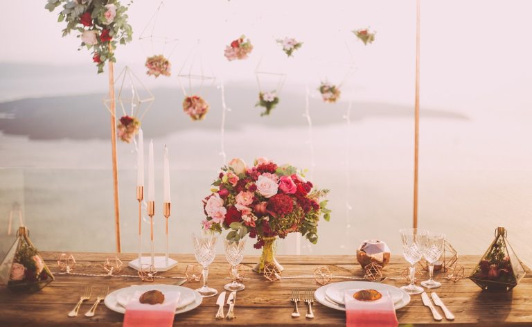 A picture showing a table laid out for a celebration with flowers and other decorations